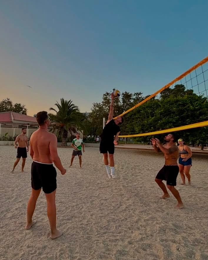 Une partie de beach-volley entre membres du club au coucher du soleil